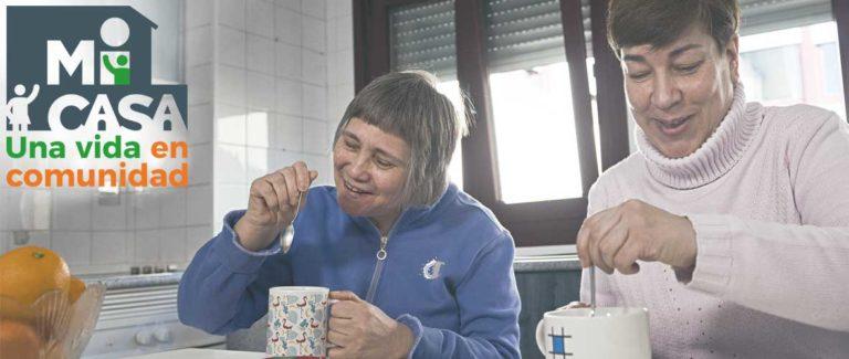 Dos mujeres desayunando en la cocina de su casa.